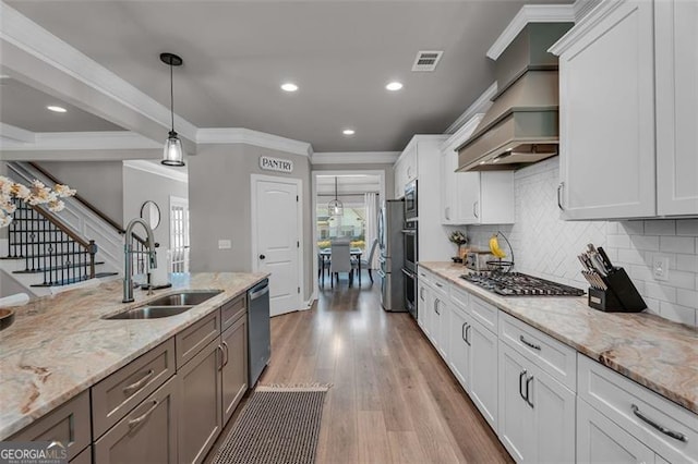 kitchen featuring crown molding, decorative backsplash, a sink, and stainless steel appliances