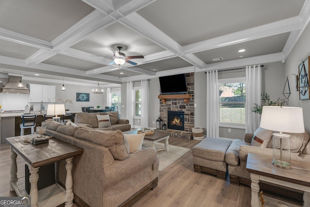 living room with plenty of natural light, light wood finished floors, beamed ceiling, and coffered ceiling