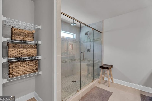 bathroom featuring tile patterned flooring, baseboards, and a stall shower