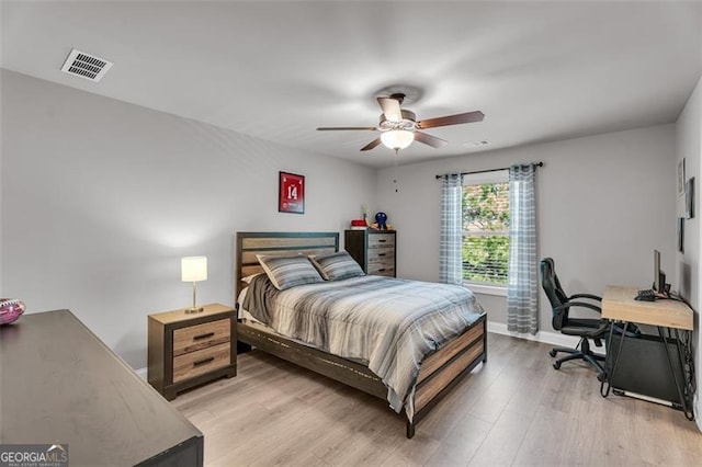 bedroom featuring visible vents, baseboards, ceiling fan, and light wood-style floors