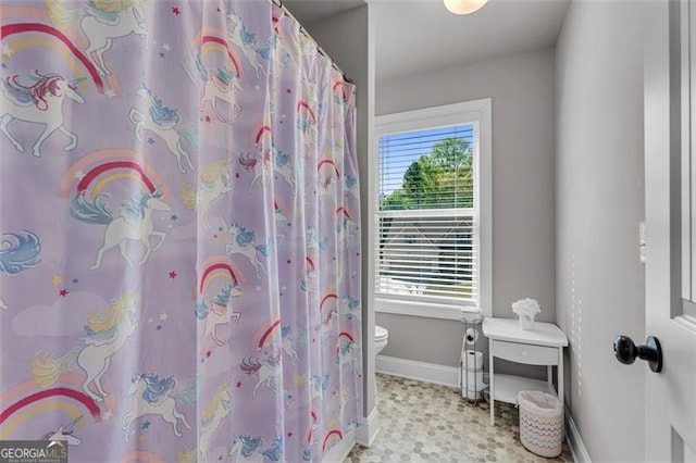 full bath with toilet, baseboards, and a shower with curtain