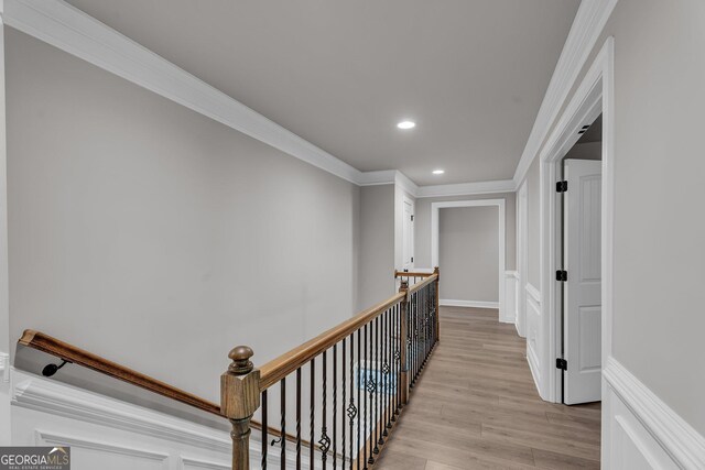 hall featuring recessed lighting, an upstairs landing, ornamental molding, and light wood finished floors