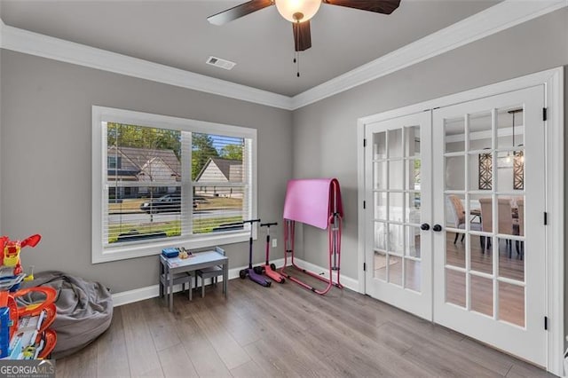 playroom featuring french doors, a ceiling fan, crown molding, visible vents, and wood finished floors