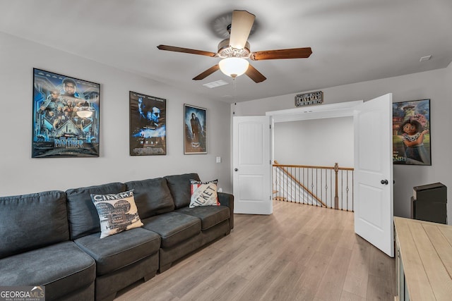 living area with light wood-style floors, visible vents, and ceiling fan
