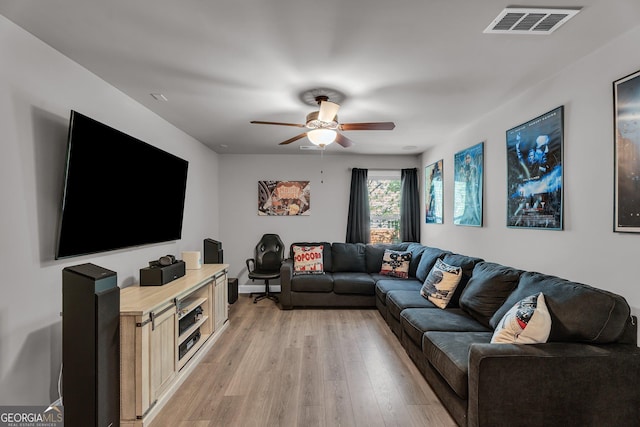 living room featuring visible vents, light wood-type flooring, and a ceiling fan