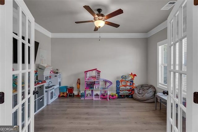 rec room featuring french doors, visible vents, crown molding, and wood finished floors