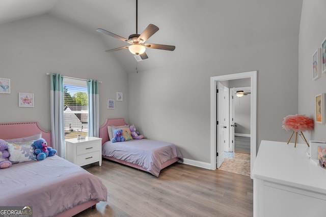 bedroom with a ceiling fan, baseboards, high vaulted ceiling, and light wood finished floors