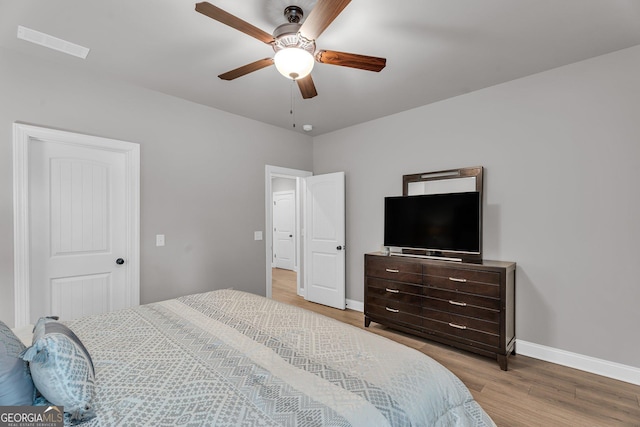 bedroom with visible vents, baseboards, light wood-type flooring, and a ceiling fan