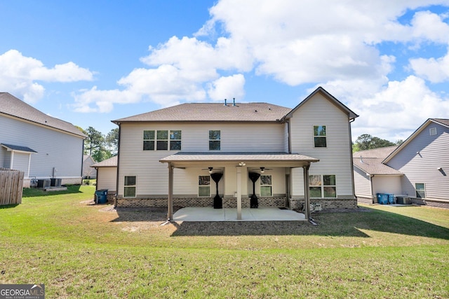 rear view of house featuring ceiling fan, a lawn, a patio area, brick siding, and central AC unit