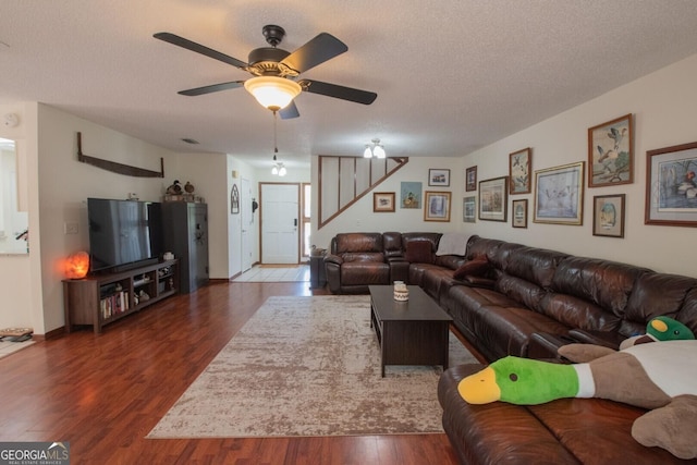 living room featuring stairs, ceiling fan, a textured ceiling, and wood finished floors
