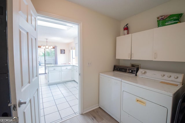 laundry area featuring independent washer and dryer, a chandelier, baseboards, and cabinet space