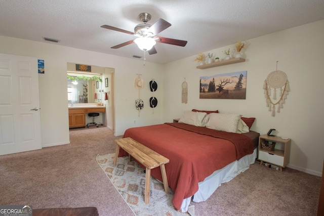 carpeted bedroom featuring ensuite bath, baseboards, and a ceiling fan
