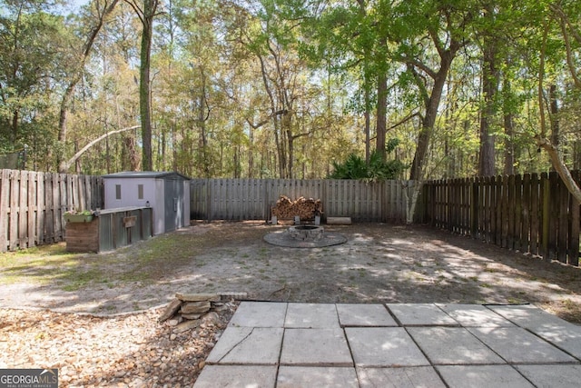 view of patio / terrace with a shed, a fenced backyard, and an outdoor structure