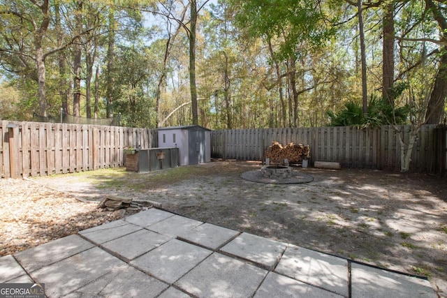 view of patio / terrace featuring an outbuilding, a fenced backyard, and a shed