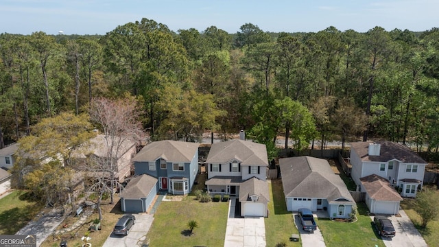drone / aerial view featuring a forest view and a residential view