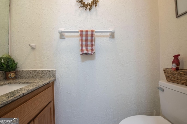 half bathroom featuring vanity and toilet