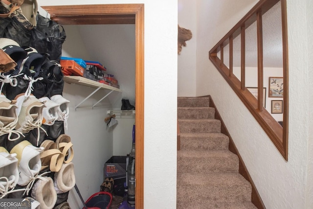 staircase featuring a textured wall