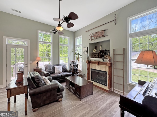 150 Fauna Meadows Dr, Newnan, GA 30263 - living area featuring ceiling fan, light wood-type flooring, plenty of natural light, and a tiled fireplace