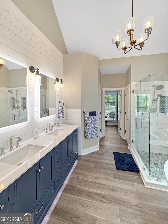 150 Fauna Meadows Dr, Newnan, GA 30263 - full bath featuring a chandelier, double vanity, a shower stall, lofted ceiling, and wood finished floors