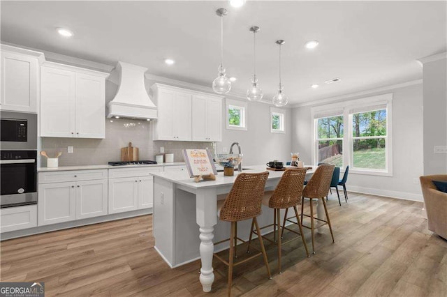 4038 Andover Cir, Mcdonough, GA 30252 - kitchen featuring custom range hood, light countertops, crown molding, a center island with sink, and stainless steel appliances