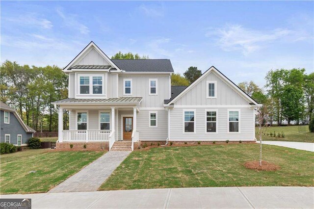 4038 Andover Cir, Mcdonough, GA 30252 - view of front of property featuring a porch, metal roof, board and batten siding, a front lawn, and a standing seam roof