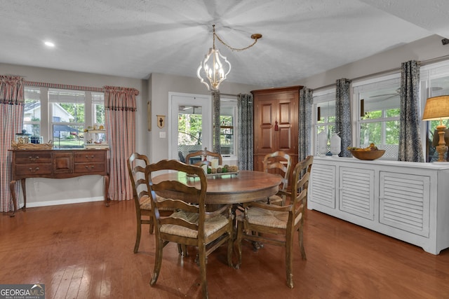 dining area with an inviting chandelier, baseboards, plenty of natural light, and wood finished floors