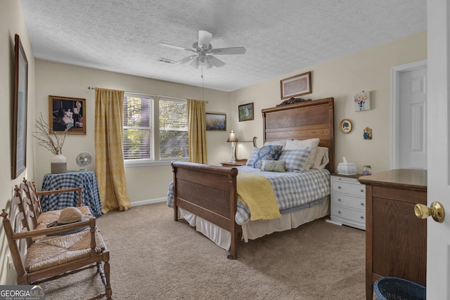 bedroom with ceiling fan, a textured ceiling, carpet, and visible vents