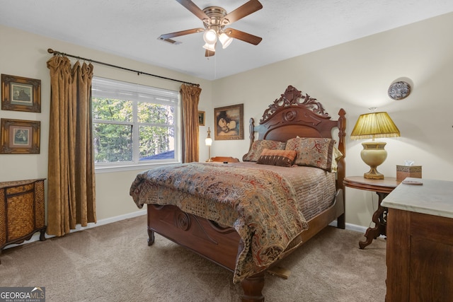 carpeted bedroom with visible vents, baseboards, and ceiling fan