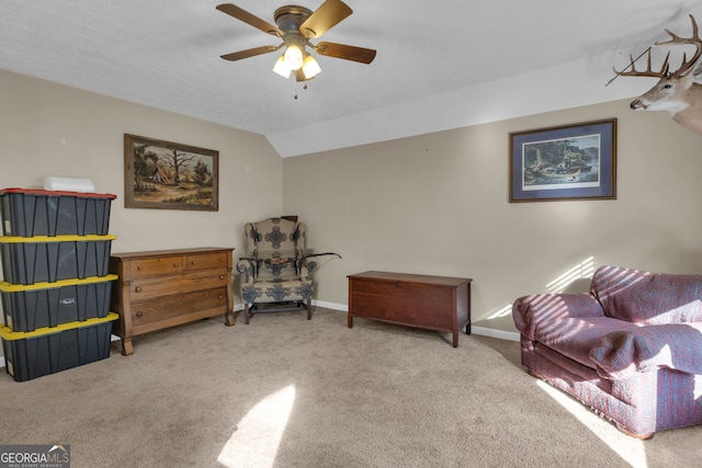 living area with vaulted ceiling, carpet flooring, baseboards, and a ceiling fan