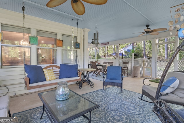 sunroom / solarium featuring a ceiling fan and plenty of natural light