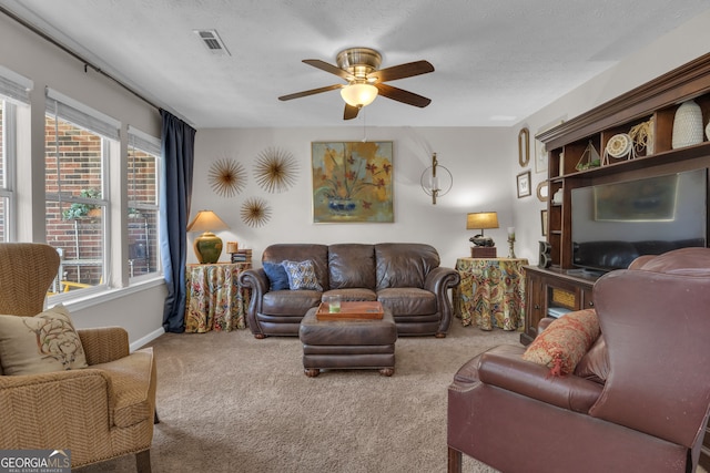 living area with a ceiling fan, baseboards, visible vents, and carpet