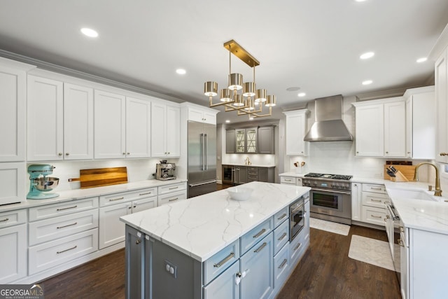 8925 Huntcliff Lake Ct, Atlanta, GA 30350 - kitchen featuring wall chimney range hood, built in appliances, white cabinets, and a sink