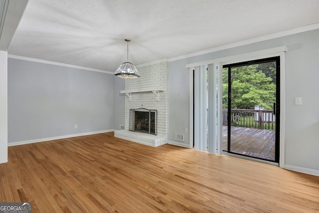 4164 Weston Dr, Powder Springs, GA 30127 - unfurnished living room with wood finished floors, ornamental molding, baseboards, a brick fireplace, and a textured ceiling