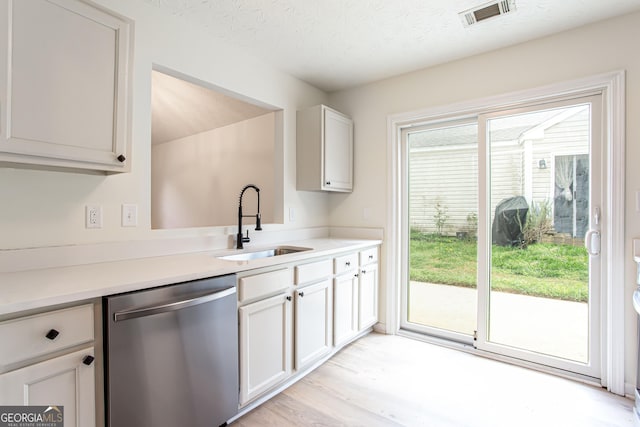 kitchen featuring a sink, visible vents, stainless steel dishwasher, and light countertops