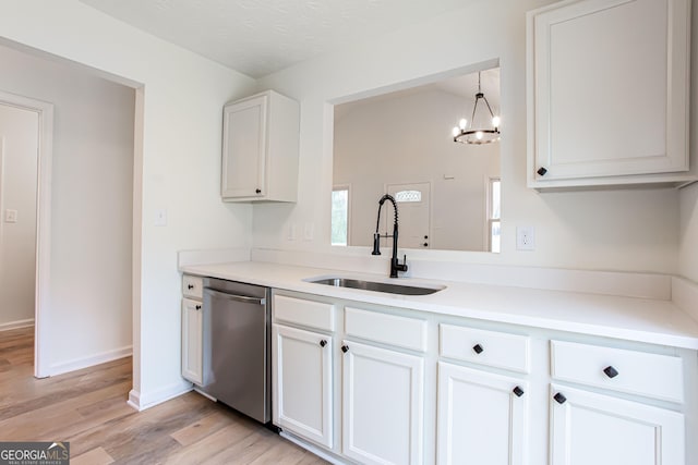 kitchen with dishwasher, a sink, a chandelier, white cabinetry, and light wood-style flooring