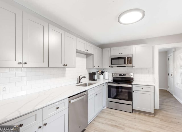 1340 Hawthorne Ave SE, Smyrna, GA 30080 - kitchen with light stone countertops, a sink, backsplash, and appliances with stainless steel finishes