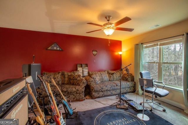living room with visible vents, carpet flooring, and ceiling fan