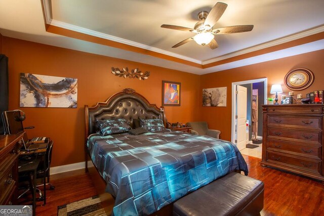 bedroom with crown molding, ceiling fan, baseboards, wood finished floors, and ensuite bathroom