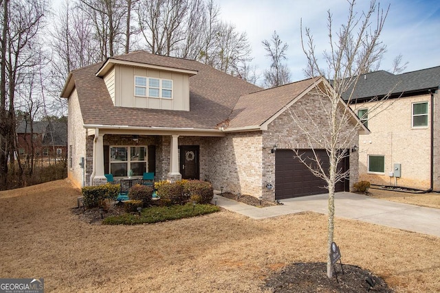 view of front of house with covered porch, an attached garage, concrete driveway, and a front lawn