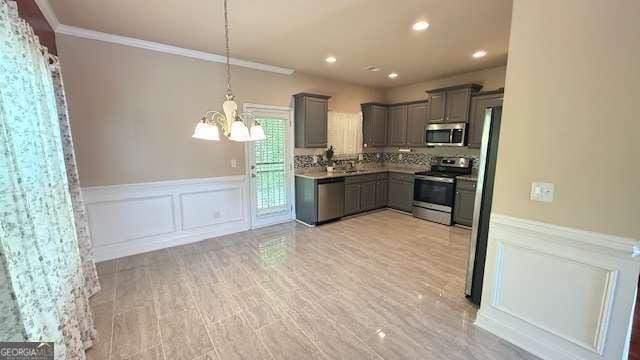 kitchen with crown molding, appliances with stainless steel finishes, wainscoting, a chandelier, and gray cabinets