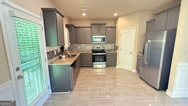 kitchen with recessed lighting, light countertops, a sink, gray cabinetry, and stainless steel appliances