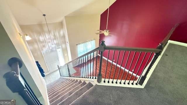 stairs with carpet flooring and ceiling fan