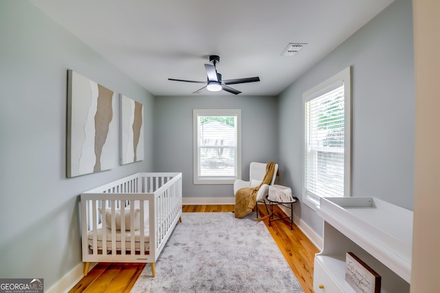 3244 Mount Olive Rd, Atlanta, GA 30344 - bedroom with wood finished floors, a nursery area, baseboards, and ceiling fan