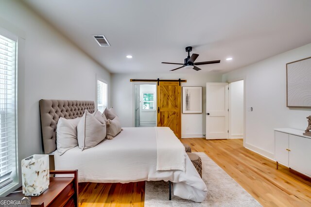 3244 Mount Olive Rd, Atlanta, GA 30344 - bedroom featuring a barn door, light wood-style flooring, recessed lighting, a ceiling fan, and baseboards