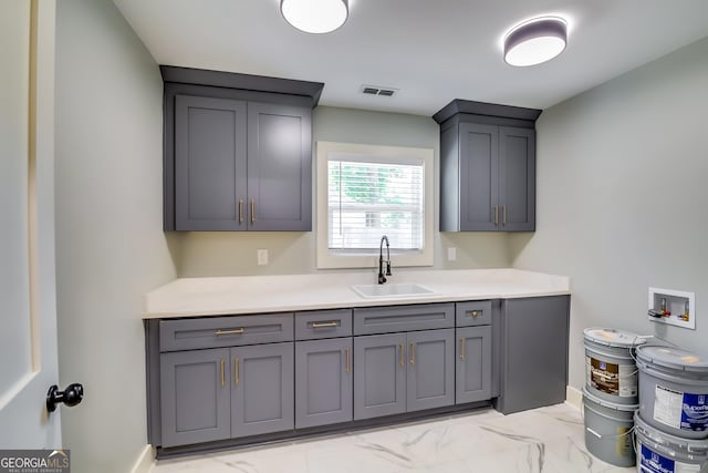 3244 Mount Olive Rd, Atlanta, GA 30344 - kitchen with a sink, gray cabinets, light marble finish flooring, and light countertops