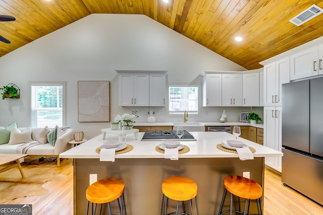 3244 Mount Olive Rd, Atlanta, GA 30344 - kitchen featuring stainless steel appliances, light countertops, a breakfast bar, light wood-type flooring, and high vaulted ceiling