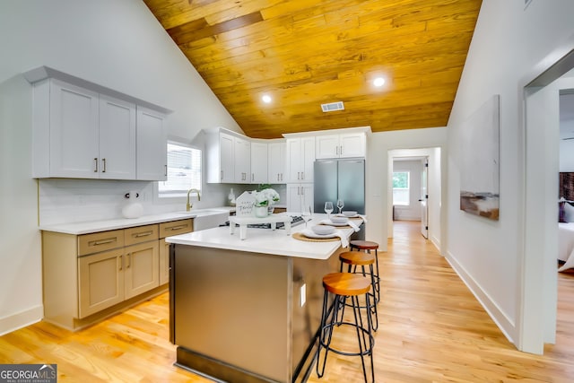 3244 Mount Olive Rd, Atlanta, GA 30344 - kitchen featuring stainless steel refrigerator, a breakfast bar, light countertops, a sink, and light wood-style flooring