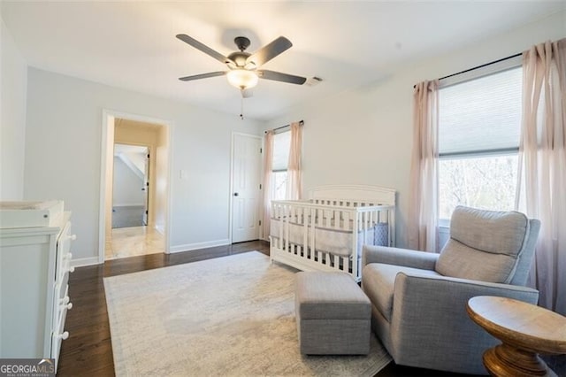 bedroom with multiple windows, dark wood-type flooring, baseboards, and a ceiling fan