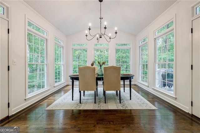 dining room with a chandelier, crown molding, dark wood-style flooring, lofted ceiling, and baseboards
