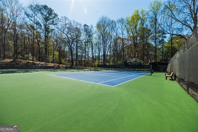 view of tennis court featuring fence